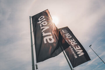 zwei Fahnen in schwarz, eine mit Arvato-Logo, die andere mit dem Schriftzug "working at arvato we are on it"