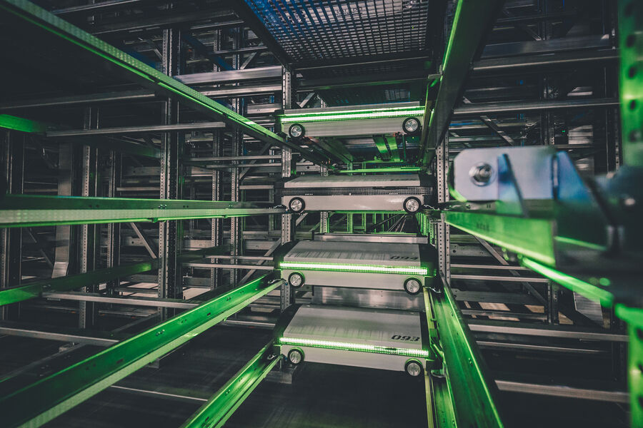 Four warehouse shuttles vertically arranged among each other in a high-bay warehouse for order fulfillment
