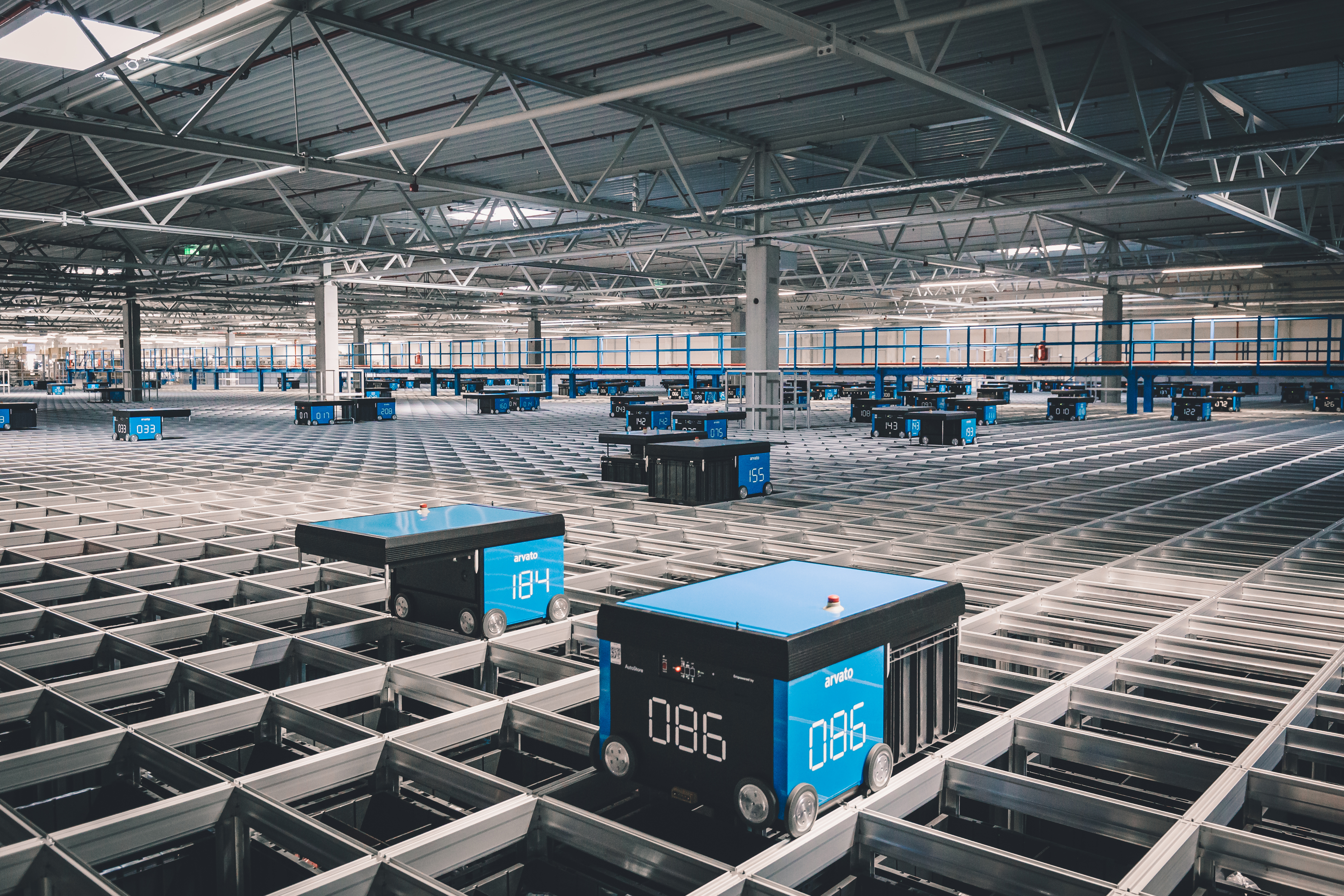 ein horizontales Autostore-Gitter mit Robotern, die Kisten mit Unterhaltungselektronik-Artikeln bewegen
